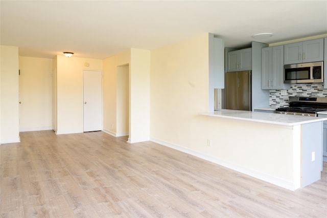 610 Waring Ave Unit 5F, Bronx, NY 10467 - kitchen featuring appliances with stainless steel finishes, light countertops, light wood-type flooring, and backsplash