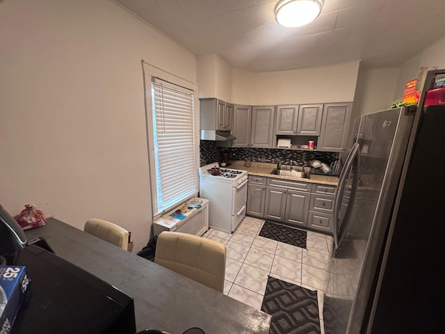 1492 E 45th St, Brooklyn, NY 11234 - kitchen with white range with gas cooktop, freestanding refrigerator, gray cabinets, under cabinet range hood, and light countertops