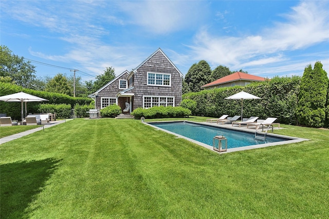 63 Armande St, Southampton, NY 11968 - rear view of house with an outdoor pool and a lawn