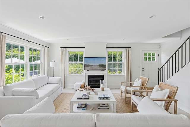 63 Armande St, Southampton, NY 11968 - living area featuring healthy amount of natural light, a glass covered fireplace, stairway, and recessed lighting