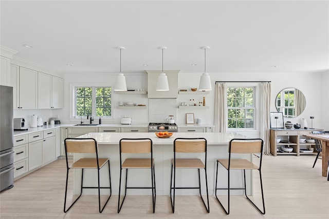 63 Armande St, Southampton, NY 11968 - kitchen with open shelves, a kitchen breakfast bar, light countertops, and light wood finished floors