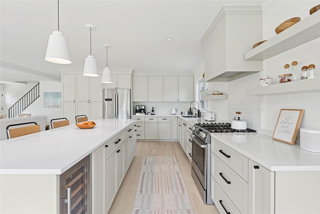 63 Armande St, Southampton, NY 11968 - kitchen with stainless steel appliances, open shelves, wine cooler, light wood-style flooring, and a kitchen island