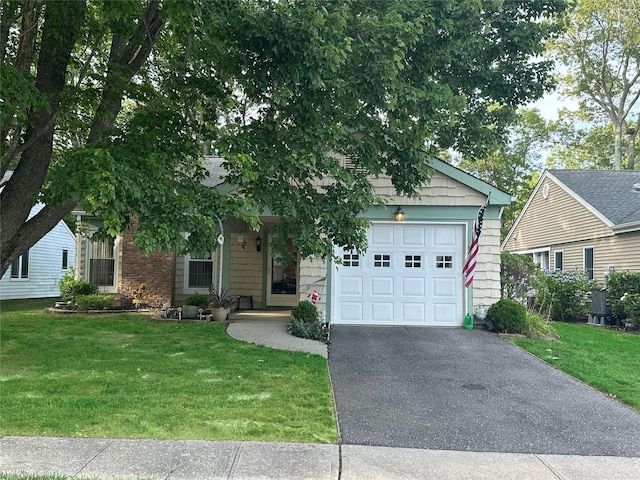 304 Kingston Ct, Ridge, NY 11961 - view of front facade featuring asphalt driveway, a front yard, and a garage