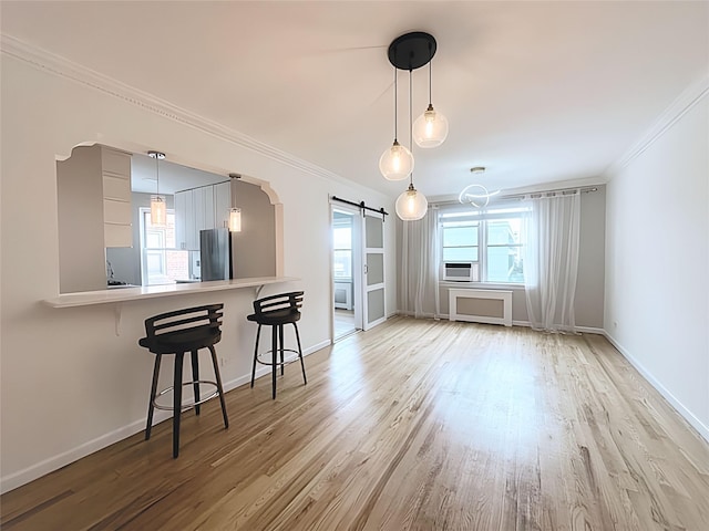 800 Grand Concourse Unit 2Js, Bronx, NY 10451 - dining room featuring a barn door, ornamental molding, light wood-type flooring, arched walkways, and cooling unit