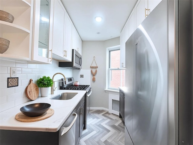 800 Grand Concourse Unit 2Js, Bronx, NY 10451 - kitchen featuring appliances with stainless steel finishes, decorative backsplash, white cabinets, and light stone countertops