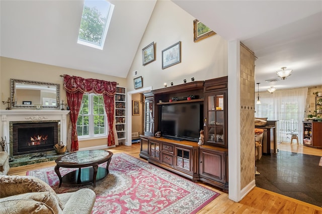 150 Hortontown Rd, Carmel, NY 10512 - living area with healthy amount of natural light, a warm lit fireplace, high vaulted ceiling, a skylight, and light wood-style flooring
