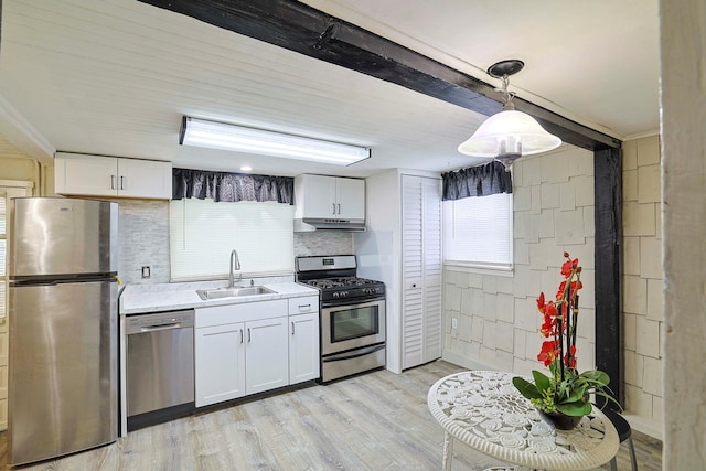 58 Wawayanda Ave, Middletown, NY 10940 - kitchen featuring appliances with stainless steel finishes, under cabinet range hood, light countertops, white cabinetry, and light wood-style floors