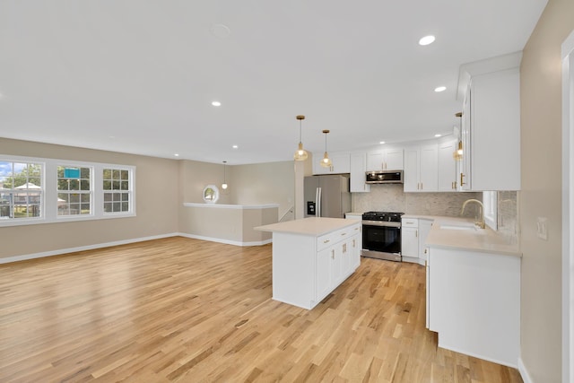 30 Wilson St, Middletown, NY 10940 - kitchen featuring appliances with stainless steel finishes, light countertops, a center island, decorative backsplash, and recessed lighting