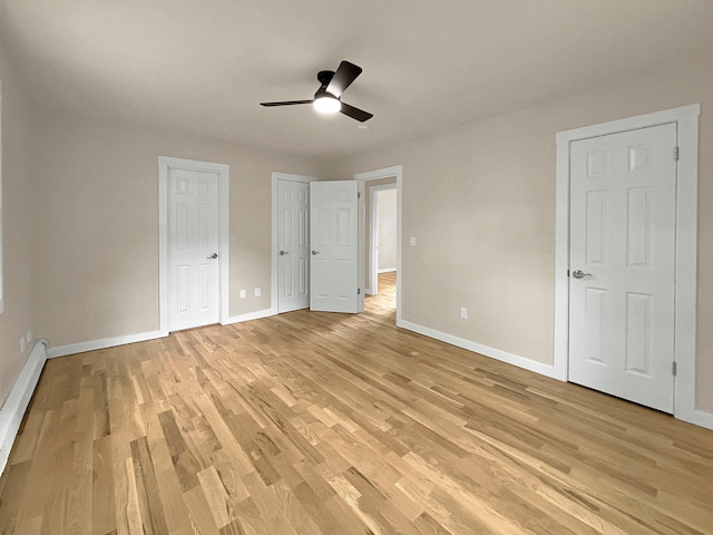 30 Wilson St, Middletown, NY 10940 - unfurnished bedroom with light wood-style flooring, a baseboard radiator, a ceiling fan, and multiple closets