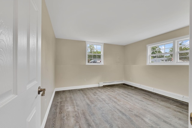 30 Wilson St, Middletown, NY 10940 - empty room featuring wood finished floors, healthy amount of natural light, and baseboard heating