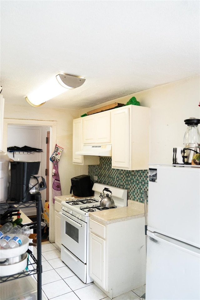 42-02 Layton St Unit 609, Elmhurst, NY 11373 - kitchen with white appliances, decorative backsplash, light countertops, under cabinet range hood, and white cabinetry