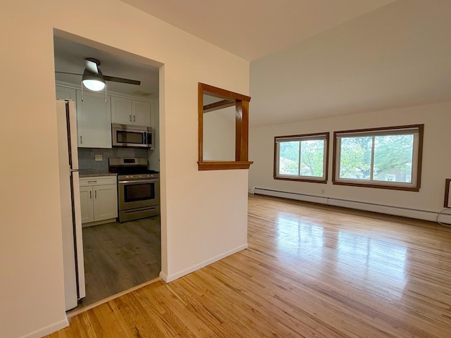 15 Blue Hill Commons, Orangeburg, NY 10962 - kitchen featuring appliances with stainless steel finishes, a baseboard heating unit, white cabinets, light wood-type flooring, and tasteful backsplash