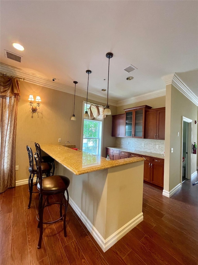 936 Tower Ridge Cir, Middletown, NY 10941 - kitchen with glass insert cabinets, a breakfast bar area, dark wood-type flooring, crown molding, and light stone counters