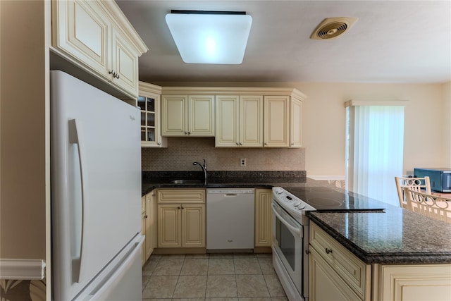 100 Baker Ct Unit 128, Island Park, NY 11558 - kitchen with white appliances, cream cabinetry, a peninsula, and light tile patterned floors