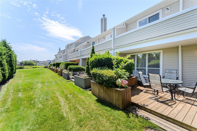 100 Baker Ct Unit 128, Island Park, NY 11558 - view of green lawn with a wooden deck and outdoor dining area