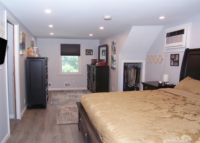 73 Peconic St, Selden, NY 11784 - bedroom with dark wood-style flooring, recessed lighting, a wall unit AC, and a walk in closet