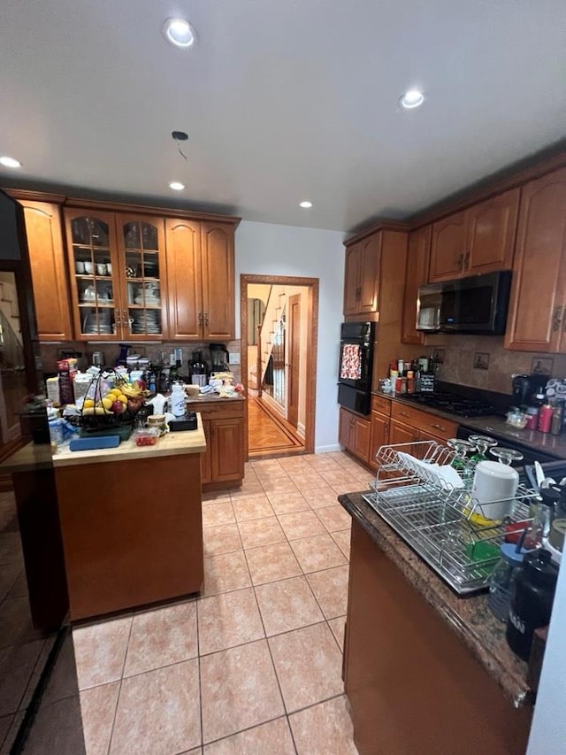 1607 E 43rd St, Brooklyn, NY 11234 - kitchen featuring black appliances, backsplash, brown cabinets, glass insert cabinets, and recessed lighting