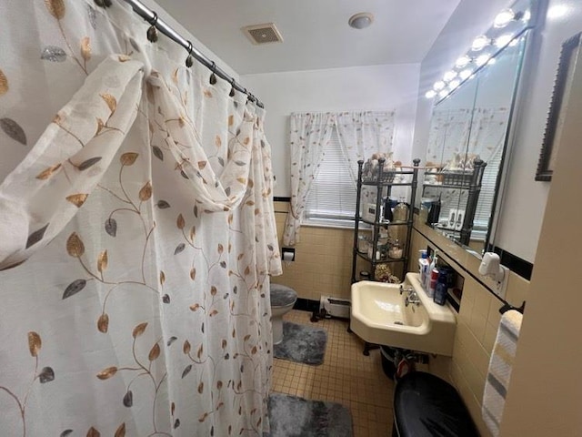 1607 E 43rd St, Brooklyn, NY 11234 - bathroom featuring tile walls, a wainscoted wall, tile patterned floors, curtained shower, and a baseboard heating unit