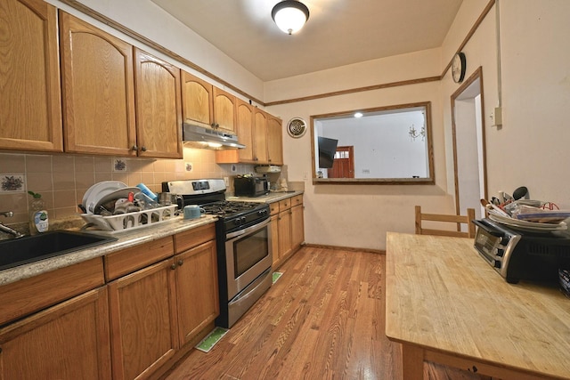 5822 Penrod St, Corona, NY 11368 - kitchen featuring gas range, under cabinet range hood, decorative backsplash, light wood finished floors, and light countertops
