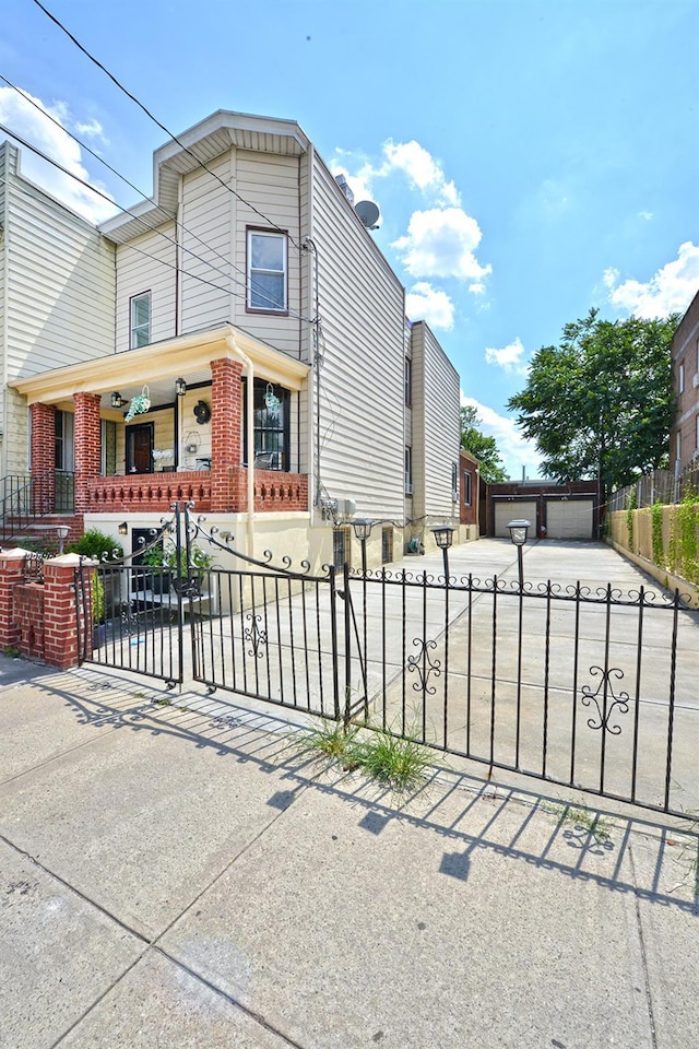 5822 Penrod St, Corona, NY 11368 - view of front of home featuring a fenced front yard, a garage, covered porch, brick siding, and driveway