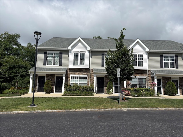 132 Weatherby Ln Unit 132, Central Islip, NY 11722 - traditional-style house featuring stone siding, a front yard, and roof with shingles