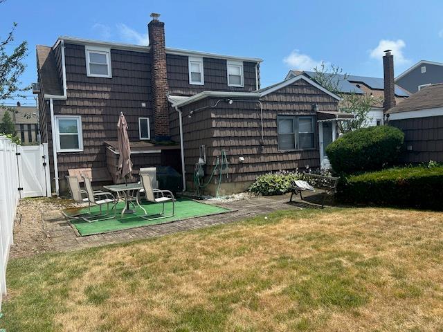 862 Peninsula Blvd, Woodmere, NY 11598 - rear view of house featuring a gate and a chimney