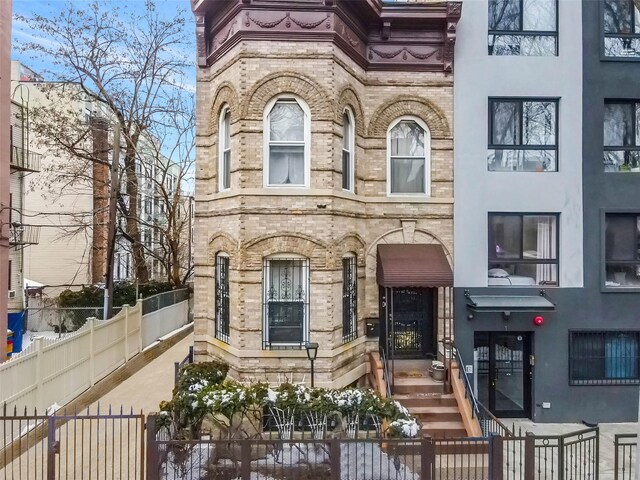 65 Granite St, Brooklyn, NY 11207 - view of front of home featuring stone siding and a fenced front yard