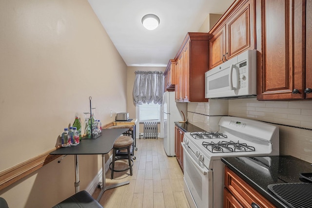 65 Granite St, Brooklyn, NY 11207 - kitchen featuring white appliances, radiator heating unit, decorative backsplash, and dark stone countertops