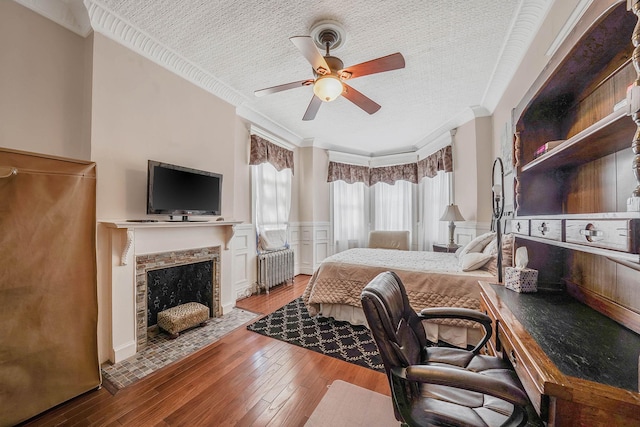 65 Granite St, Brooklyn, NY 11207 - bedroom with radiator heating unit, ornamental molding, hardwood / wood-style flooring, wainscoting, and a tiled fireplace