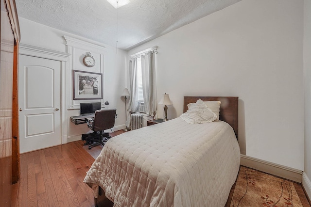 65 Granite St, Brooklyn, NY 11207 - bedroom featuring hardwood / wood-style flooring, radiator heating unit, a textured ceiling, and a desk