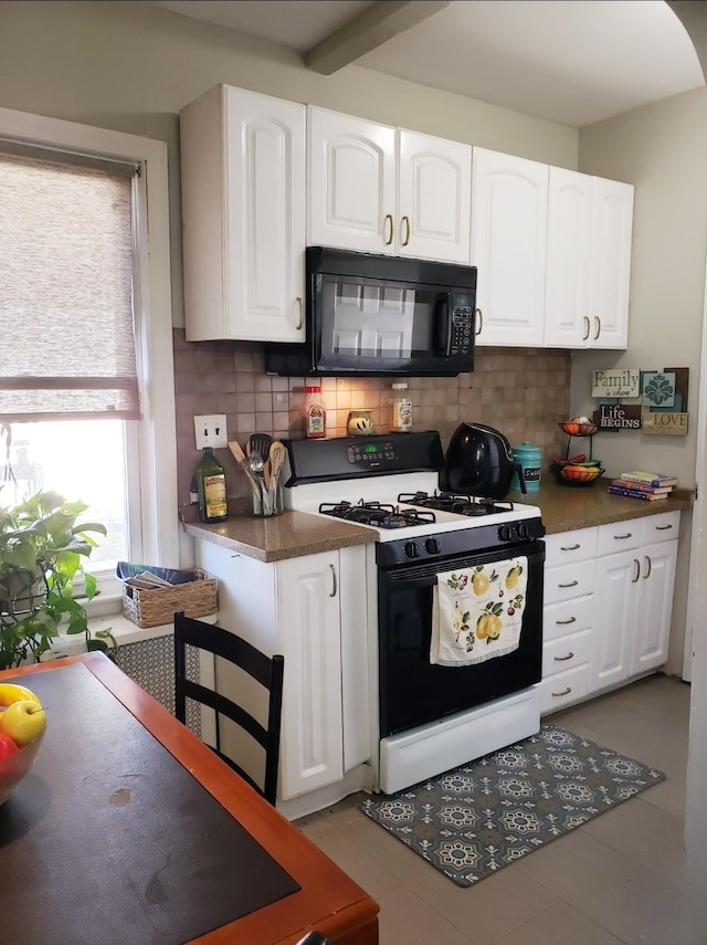 269 Windsor Pkwy, Hempstead, NY 11550 - kitchen with gas range oven, black microwave, tasteful backsplash, white cabinets, and dark countertops