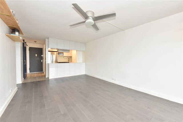 152-18 Union Tpke Unit 12T, Flushing, NY 11367 - unfurnished living room with a barn door, dark wood-type flooring, and a ceiling fan