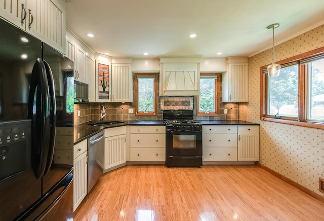 3 N Jackson Rd, Poughkeepsie, NY 12603 - kitchen with black appliances, wallpapered walls, light wood finished floors, dark countertops, and custom exhaust hood