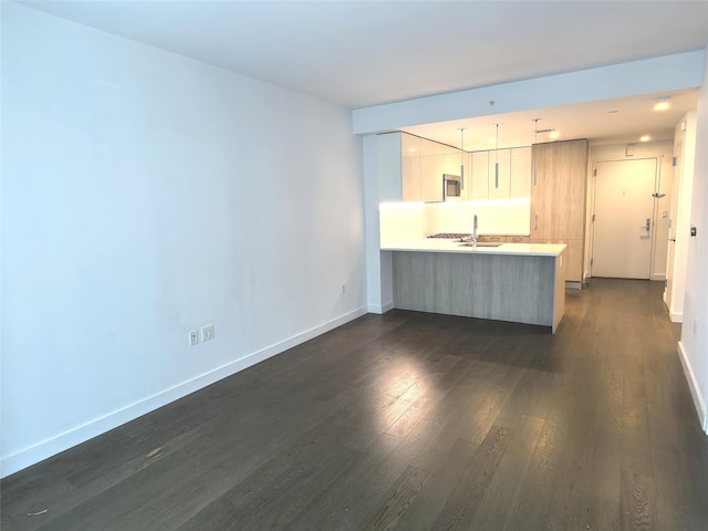 131-05 40th Rd Unit 17L, Flushing, NY 11354 - kitchen with stainless steel microwave, a peninsula, dark wood finished floors, light countertops, and modern cabinets