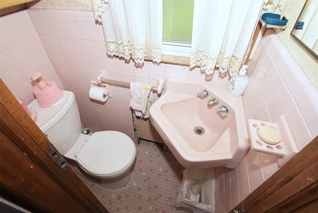 57 Nieman Ave, Lynbrook, NY 11563 - half bathroom with tile patterned floors, tile walls, and healthy amount of natural light
