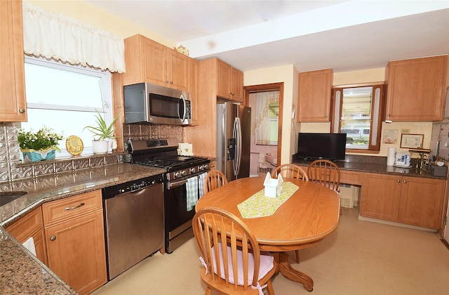 57 Nieman Ave, Lynbrook, NY 11563 - kitchen with stainless steel appliances, backsplash, and dark stone counters