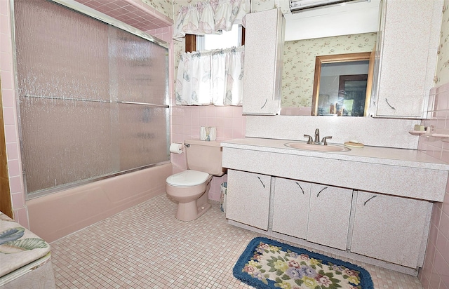 57 Nieman Ave, Lynbrook, NY 11563 - bathroom with wallpapered walls, vanity, bath / shower combo with glass door, tile walls, and tile patterned flooring