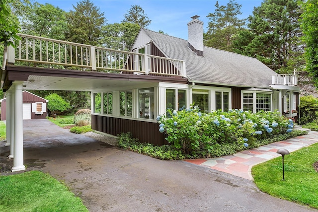 22 Turtle Cove Dr, Southampton, NY 11968 - rear view of house with roof with shingles, a chimney, a deck, driveway, and a detached garage