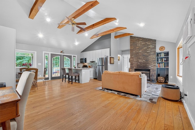 69 Floradan Rd, Putnam Valley, NY 10579 - living room with light wood-style floors, beam ceiling, high vaulted ceiling, a ceiling fan, and a fireplace
