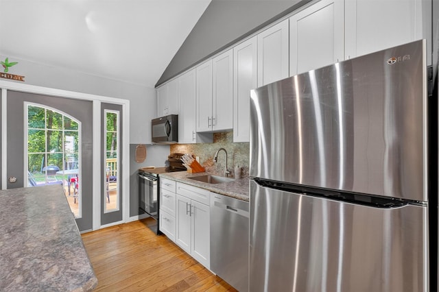 69 Floradan Rd, Putnam Valley, NY 10579 - kitchen featuring appliances with stainless steel finishes, lofted ceiling, backsplash, light wood-type flooring, and white cabinetry