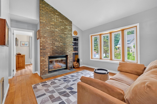 69 Floradan Rd, Putnam Valley, NY 10579 - living room with light wood-type flooring, a brick fireplace, and high vaulted ceiling