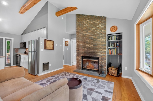 69 Floradan Rd, Putnam Valley, NY 10579 - living room featuring light wood finished floors, high vaulted ceiling, a fireplace, beam ceiling, and heating unit