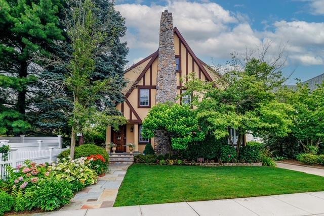 11 Loel Ct, Rockville Centre, NY 11570 - tudor-style house featuring a chimney and stucco siding