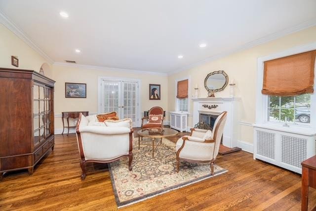 11 Loel Ct, Rockville Centre, NY 11570 - living area featuring french doors, wood finished floors, radiator heating unit, crown molding, and a fireplace