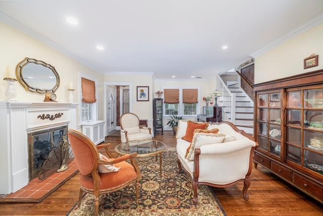 11 Loel Ct, Rockville Centre, NY 11570 - living room featuring stairway, ornamental molding, wood finished floors, a tile fireplace, and recessed lighting
