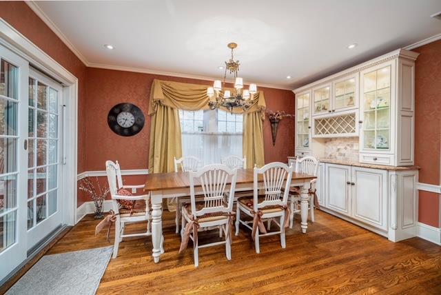 11 Loel Ct, Rockville Centre, NY 11570 - dining space with wood finished floors, a chandelier, and ornamental molding