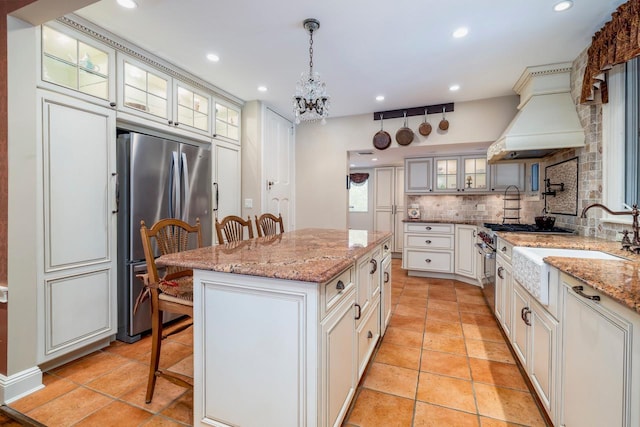 11 Loel Ct, Rockville Centre, NY 11570 - kitchen with appliances with stainless steel finishes, a breakfast bar, tasteful backsplash, a center island, and recessed lighting