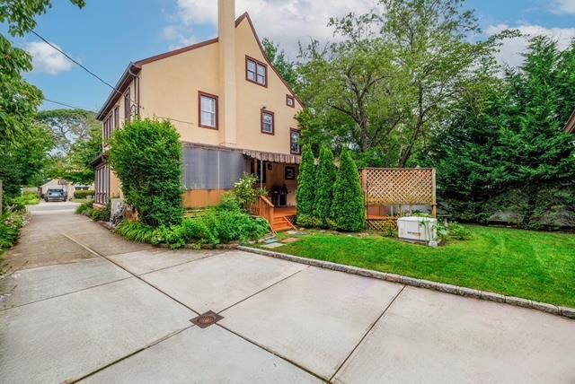 11 Loel Ct, Rockville Centre, NY 11570 - view of side of property with stucco siding and a yard