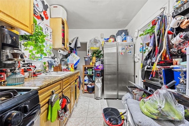 2719 Hering Ave, Bronx, NY 10469 - kitchen with freestanding refrigerator, black gas range oven, light tile patterned floors, and brown cabinetry