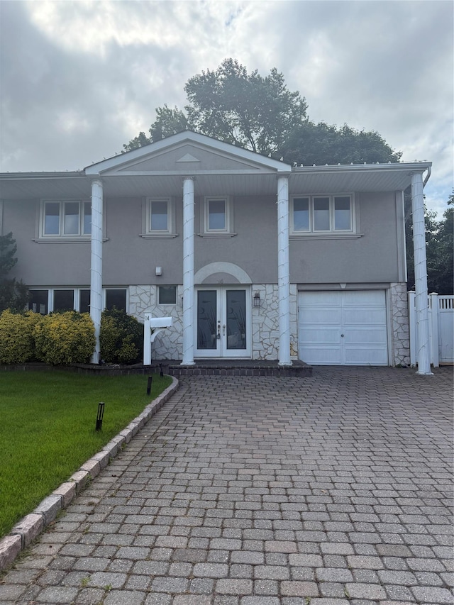 14 Foxrood Rd, Old Bethpage, NY 11804 - neoclassical / greek revival house with stucco siding, a garage, stone siding, french doors, and decorative driveway